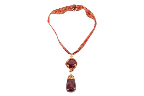 Lot 204 - A Chinoiserie spinel drop pendant on ribbon...