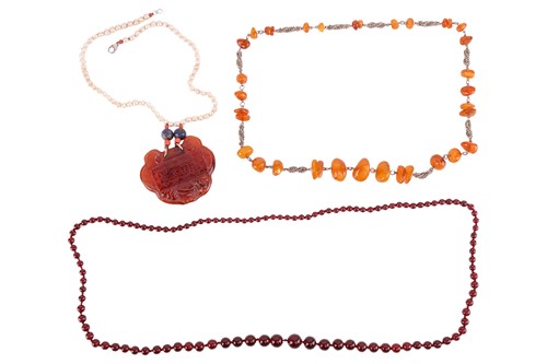 Lot 147 - Three amber necklaces; to include a single...