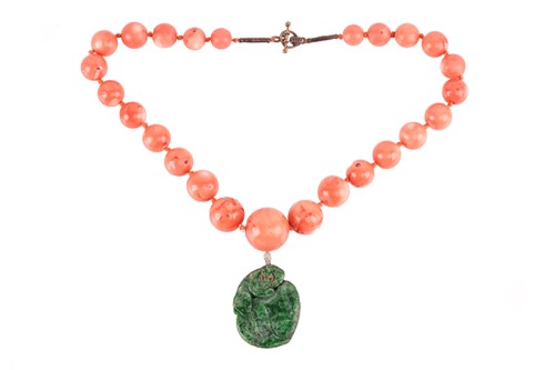 Lot 201 - A carved jade pendant and coral bead necklace,...