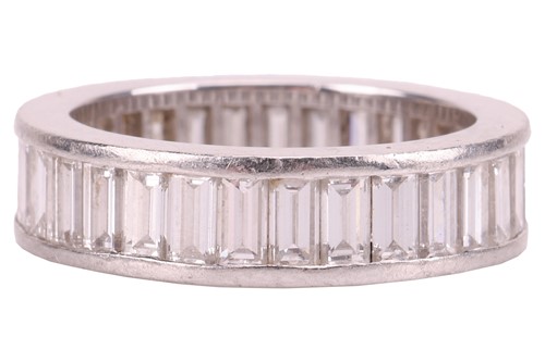 Lot 42 - A baguette-cut diamond eternity ring,...