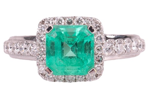 Lot 104 - An emerald and diamond cluster ring in 18ct...