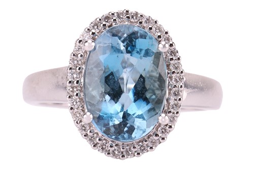 Lot 142 - An aquamarine and diamond halo ring in 18ct...