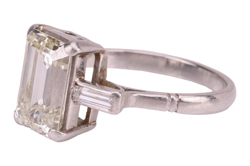 Lot 231 - An emerald-cut diamond trilogy ring, with an...