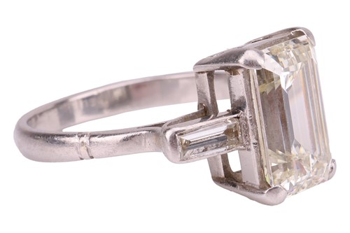 Lot 231 - An emerald-cut diamond trilogy ring, with an...