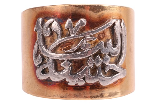 Lot 40 - A two-toned Arabic script ring, the wide and...