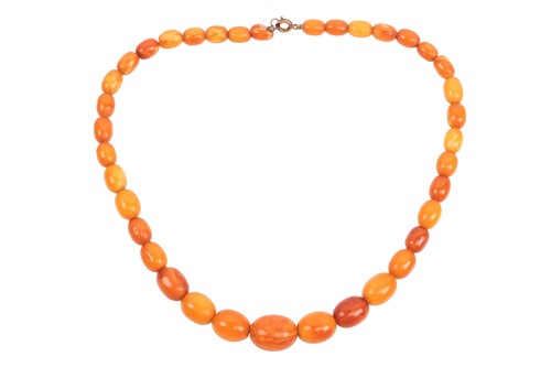 Lot 210 - An amber bead necklace; comprising a row of...