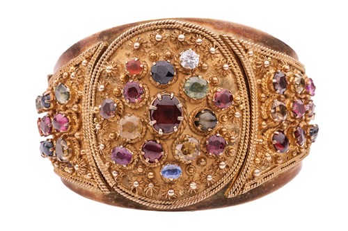 Lot 194 - A multi-gem hinged bangle in gilt metal, of...