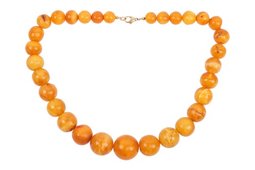 Lot 212 - A single strand amber bead necklace,...