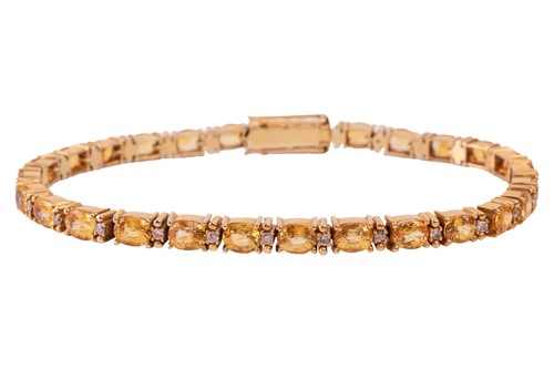 Lot 209 - A yellow sapphire line bracelet, featuring...