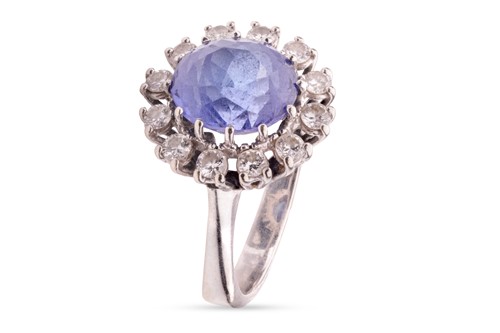 Lot 148 - A tanzanite and diamond cluster ring, centred...