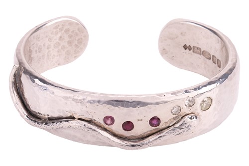 Lot 187 - A silver, diamond and ruby snake bangle, the...