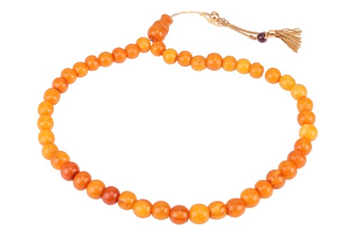 Lot 198 - A string of amber 'prayer' or 'worry' beads;...