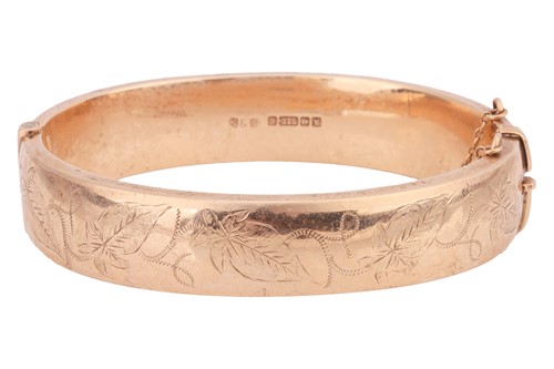 Lot 147 - A 9ct gold hollow bangle, the front engraved...