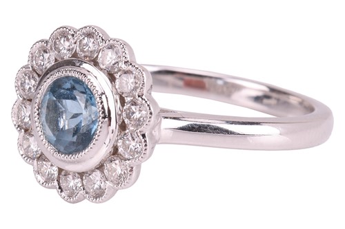 Lot 71 - An aquamarine and diamond halo ring in 18ct...