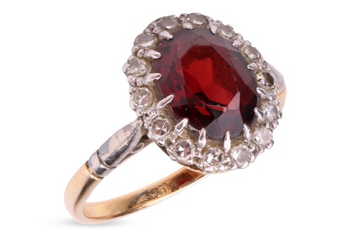 Lot 141 - A garnet and diamond halo ring, centred with...