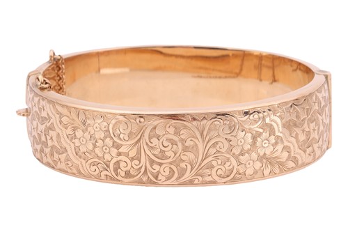 Lot 29 - A 9ct gold hinged bangle, with floral, scroll...