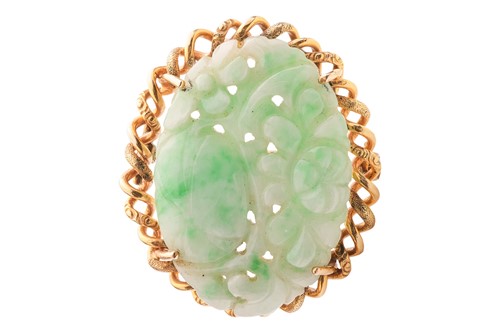 Lot 61 - A carved jade brooch, the oval jade plaque...