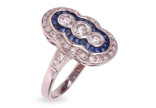 Lot 292 - A diamond and sapphire panel ring in 18ct...