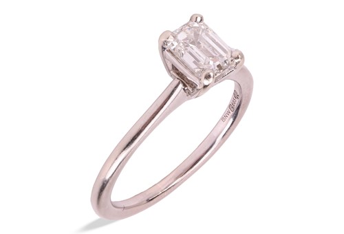 Lot 40 - An emerald-cut diamond solitaire ring in 14ct...