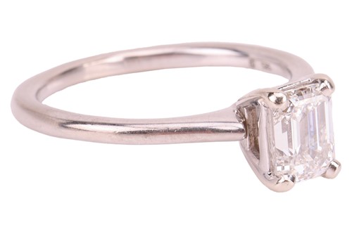 Lot 40 - An emerald-cut diamond solitaire ring in 14ct...