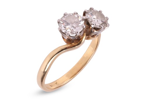 Lot 302 - A diamond-set crossover ring, claw-set with...