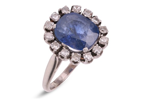 Lot 233 - A sapphire and diamond cluster ring, centred...