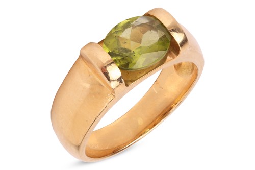 Lot 143 - A peridot ring, featuring an oval mixed-cut...