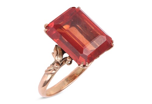Lot 183 - A synthetic orange sapphire ring, with an...