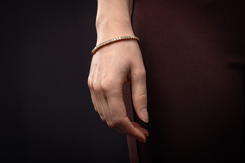Lot 252 - A diamond line bracelet, with an estimated...