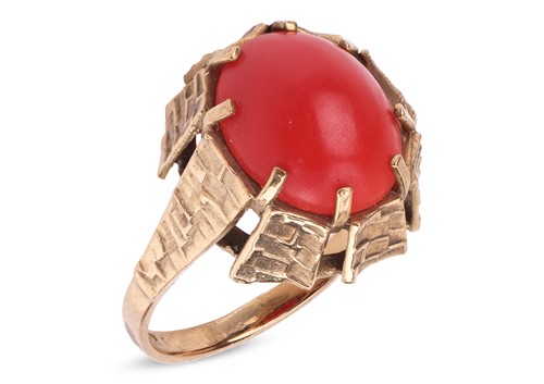 Lot 11 - A coral cabochon dress ring, set with an oval...