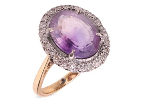 Lot 42 - An amethyst and diamond halo ring, claw-set...