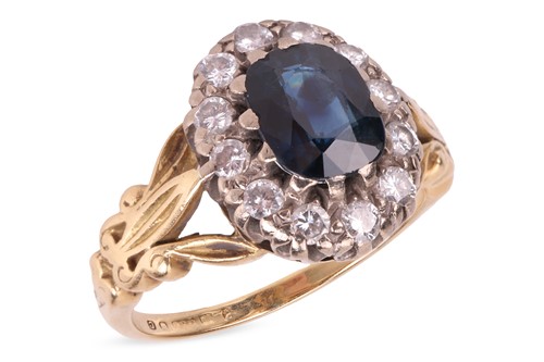 Lot 24 - A sapphire and diamond halo ring in 18ct gold,...