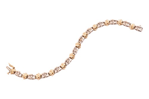 Lot 125 - A two-tone diamond-set line bracelet, with an...