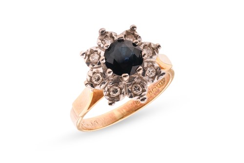 Lot 57 - A diamond and sapphire cluster ring, featuring...