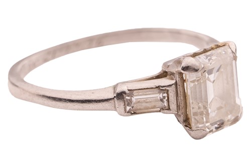 Lot 90 - An emerald-cut diamond solitaire ring,...