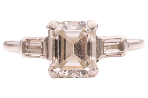 Lot 90 - An emerald-cut diamond solitaire ring,...