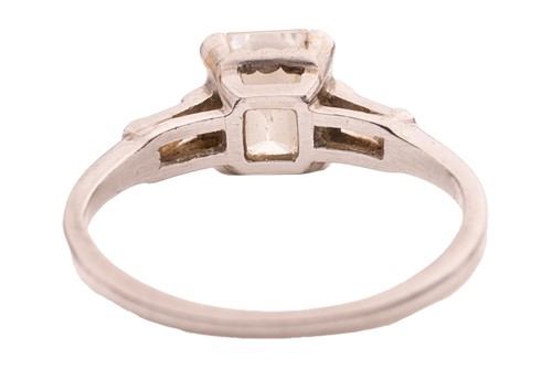 Lot 90 - An emerald-cut diamond solitaire ring,...