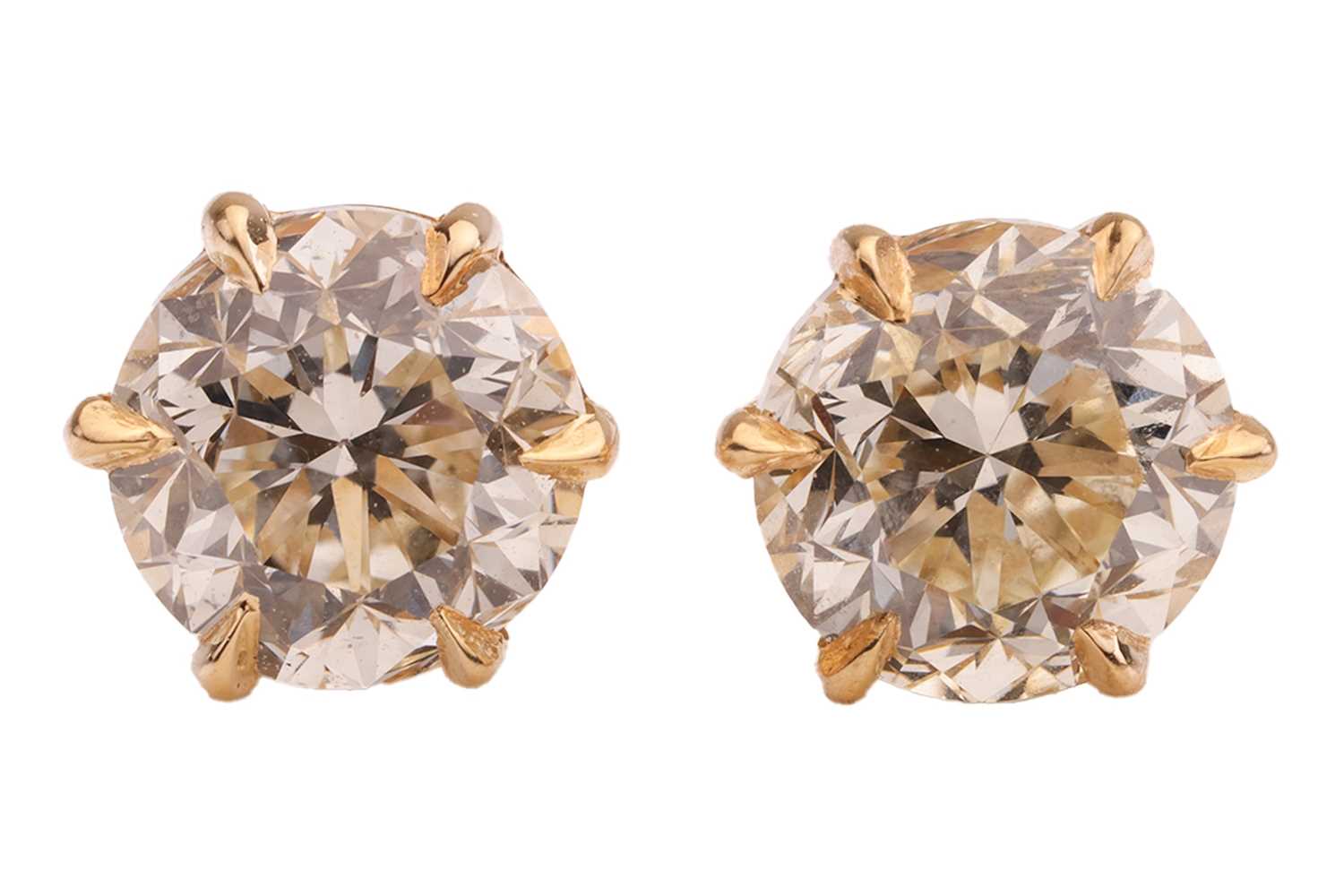 Lot 293 - A pair of diamond stud earrings, with a total...