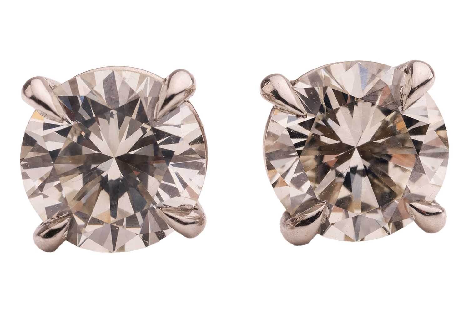 Lot 299 - A pair of diamond stud earrings, with a total...