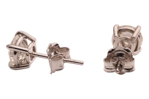 Lot 299 - A pair of diamond stud earrings, with a total...