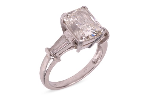 Lot 263 - A radiant-cut diamond ring, the central...