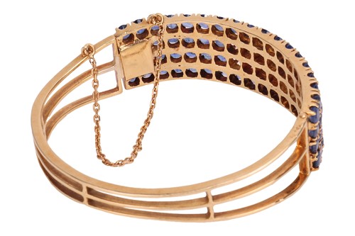 Lot 77 - A sapphire and diamond hinged bangle,...