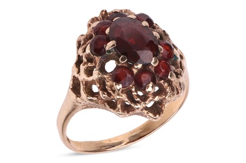 Lot 90 - A garnet-set cluster ring, the central oval...
