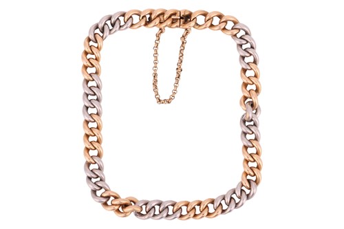 Lot 177 - A two-tone curb link bracelet, comprising a...