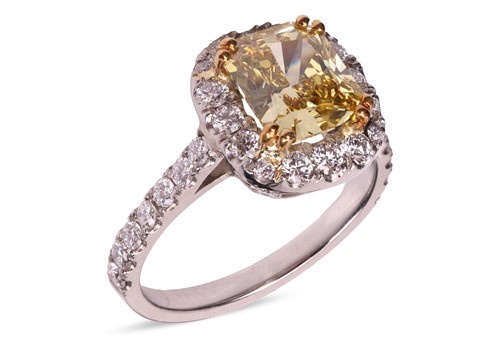 Lot 193 - A Fancy Intense yellow diamond cluster ring,...