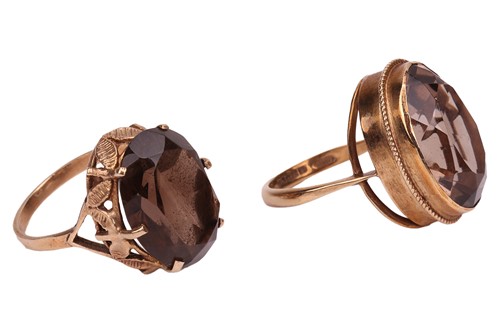 Lot 15 - Two smoky quartz rings; both set with oval-cut...