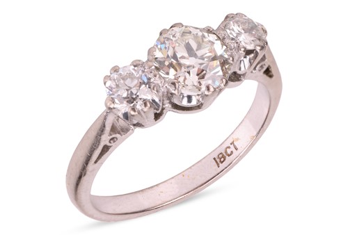 Lot 137 - A diamond three-stone ring, claw-set with...