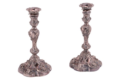 Lot 320 - A pair of George II silver cast candlesticks,...