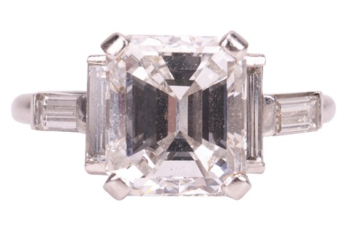 Lot 206 - An emerald-cut diamond ring, featuring an...