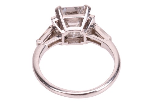 Lot 206 - An emerald-cut diamond ring, featuring an...